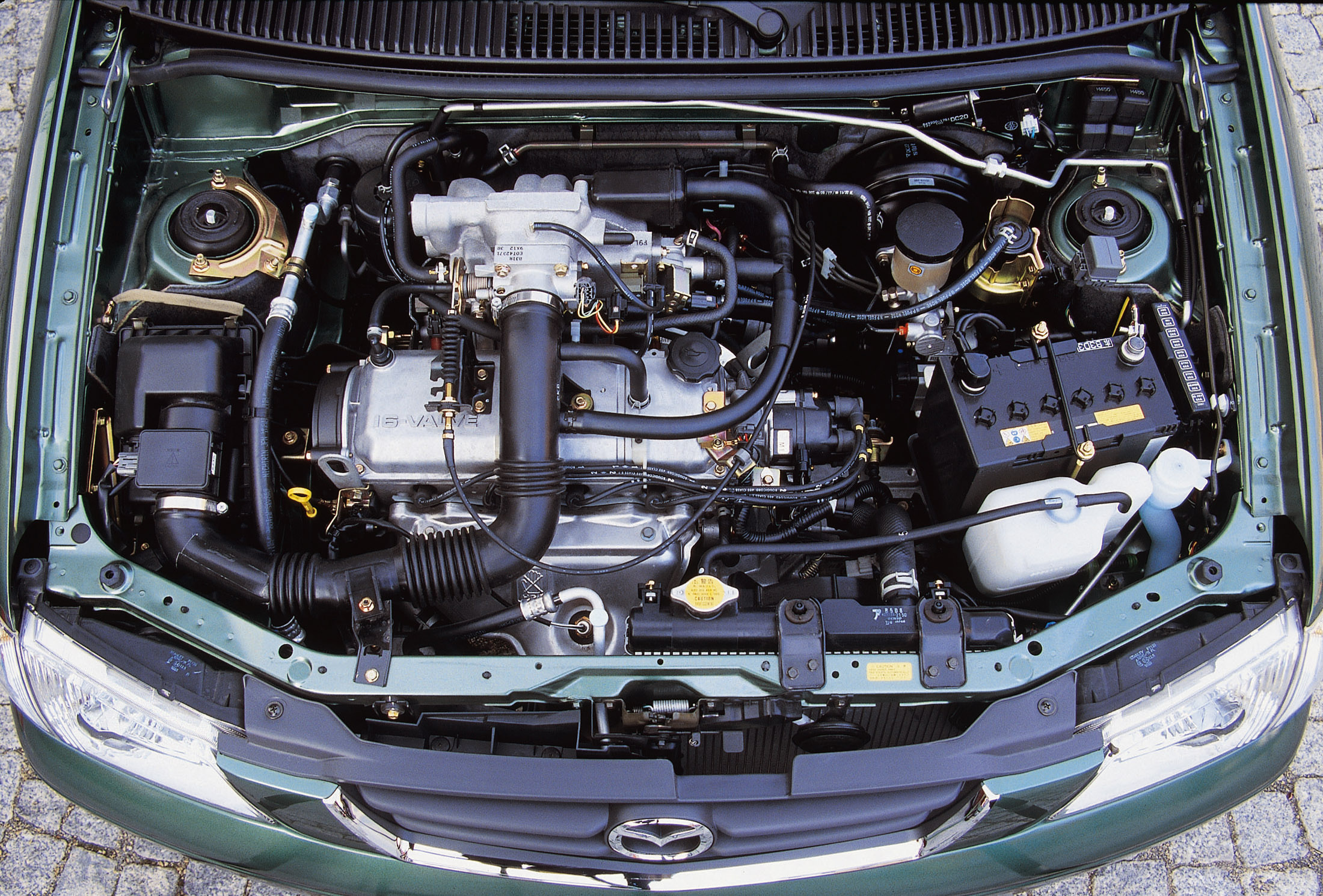 Mazda demio двигатели. Mazda Demio 1998 моторный отсек. Мазда Демио 2000. Мазда Демио 2000 под капотом. Mazda Demio 2000 1.3 мотор.